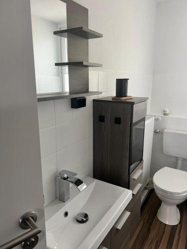 a white bathroom with a toilet and a sink at Heavens Wink in Emmerich