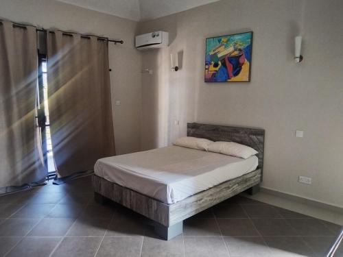 a bedroom with a bed and a painting on the wall at residence exotica in Île aux Chats