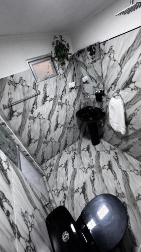 a bathroom with a toilet and a marble wall at Hidden Treasure in Nuwara Eliya