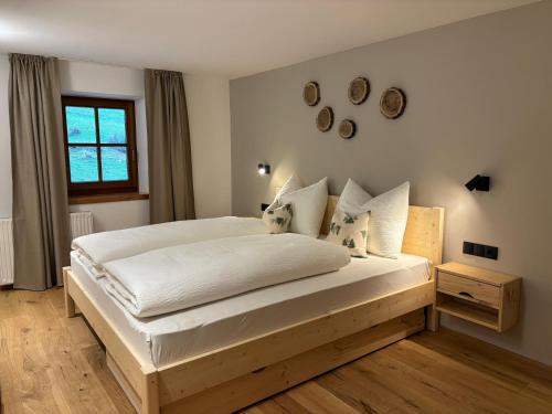 a bedroom with a large bed with white sheets and pillows at Hanselerhof Jaufental Ratschings mit Sauna in Racines