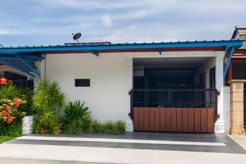 Simpang EmpatにあるWelcome to MANAF HOME STAY, 3 Fully Furnished bedrooms, located in beautiful Alor Gajah, Melakaの門と青屋根の白い家
