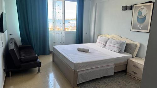 Masaki H and Apartment في دار السلام: غرفة نوم بها سرير وكرسي ونافذة