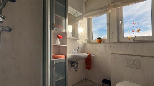 a white bathroom with a sink and a window at FeWo Blickweite in Hessisch Oldendorf
