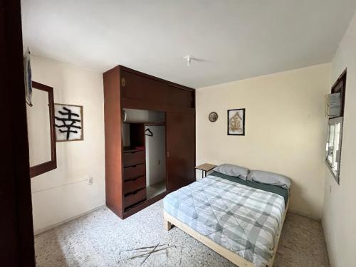 a bedroom with a bed and a dresser at Casona el Sol in Veracruz