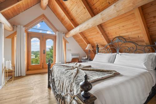 a bedroom with a large bed with a wooden ceiling at Hébergement "La Maison en Bois Rond" in Sainte-Marie