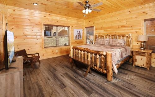 a bedroom with a bed in a log cabin at Cate + Cali's Place - Private Indoor Pool, Game Room + Outdoor Hot Tub in Pigeon Forge