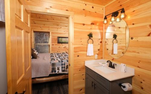 a bathroom with a sink and a bed in a room at Cate + Cali's Place - Private Indoor Pool, Game Room + Outdoor Hot Tub in Pigeon Forge