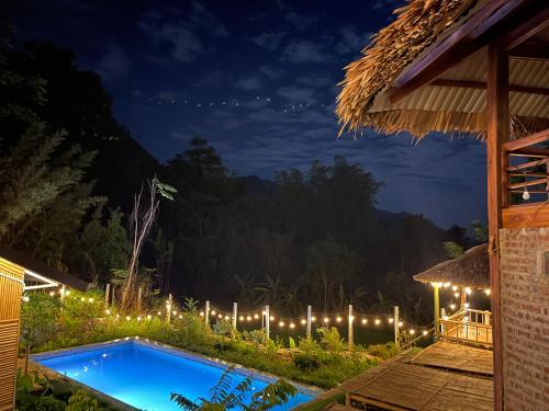 a resort swimming pool at night with lights at Mai Châu Medifarm Retreat in Mai Chau