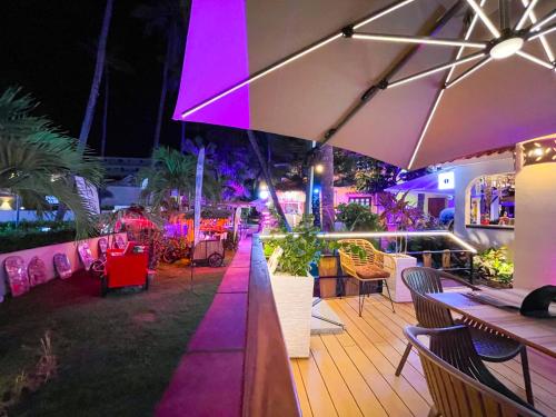 プンタ・カナにあるLOS CORALES Hotel Resort Villas & Apartments WIFI BEACH Club & SPAのテーブルと椅子と傘のあるバー