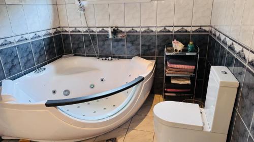 a bathroom with a large tub and a toilet at Townhouse with 4 bedrooms near Sørstrand 