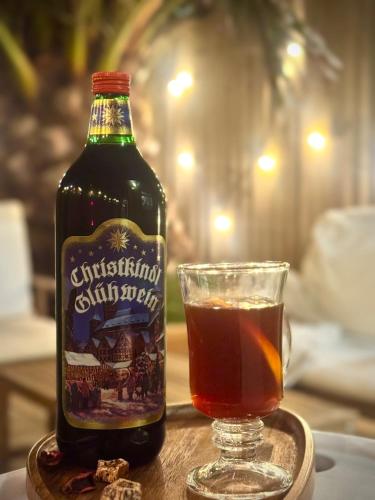 a bottle of alcohol and a glass on a table at The Palms at No10 - Spacious and Family Friendly in Rodwell