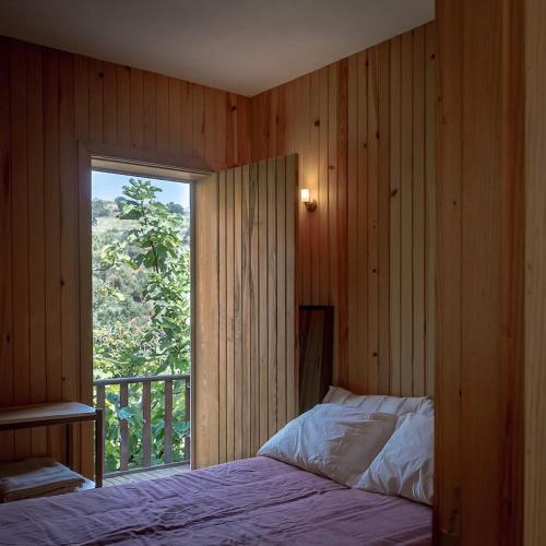 a bedroom with a bed and a large window at WABI SABI-QuintAlão in Passô