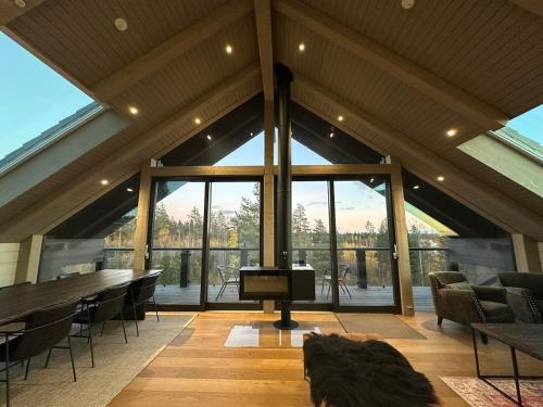 a living room with a piano and a large window at Naava Chalet 402 Penthouse - Kattohuoneisto järvinäköalalla in Ähtäri