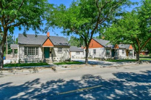 a white house with trees in front of a street at North End Bungalow 1921 Half in Boise