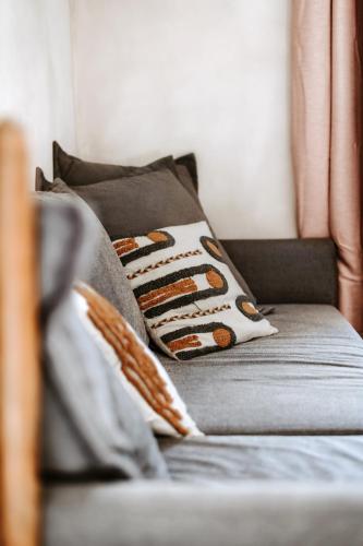 a couch with pillows on it in a living room at Gîte de la maraîchère in Ittre