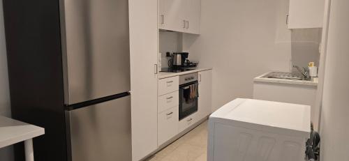 a white kitchen with a refrigerator and a stove at Habito Luxury Apartment - Breakbooking CY in Limassol
