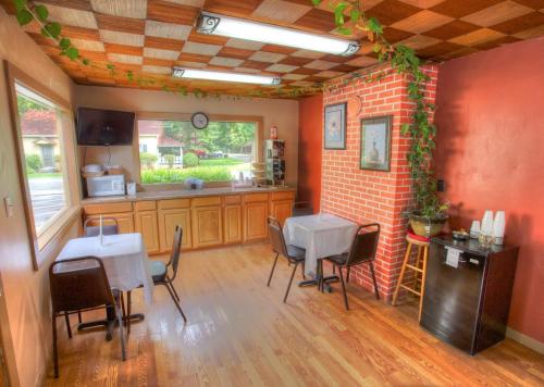 a kitchen with a table and chairs and a brick wall at Hofbrau Riverfront Hotel in Helen