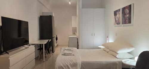 a white room with a bed and a flat screen tv at Habito Luxury Apartment - Breakbooking CY in Limassol