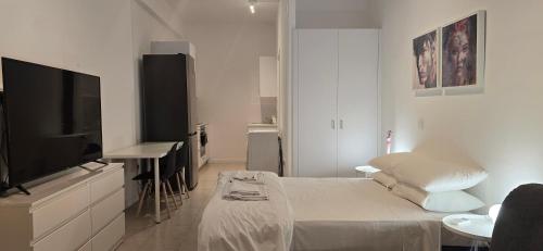 a white room with a bed and a flat screen tv at Habito Luxury Apartment - Breakbooking CY in Limassol