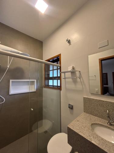 een badkamer met douche, toilet en wastafel bij Itamambuca Suites in Ubatuba