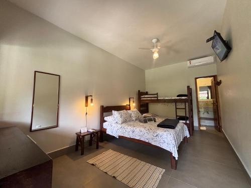 een slaapkamer met een groot bed en een spiegel bij Itamambuca Suites in Ubatuba