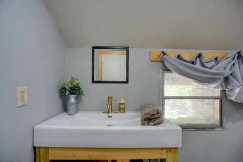 a bathroom with a white sink and a window at 6 Mi to Laughlin AFB Cozy Studio with Private Yard in Del Rio