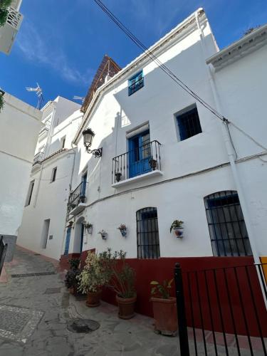 een wit gebouw met ramen en potplanten bij Guesthouse La Tienda Cómpeta 21b in Cómpeta