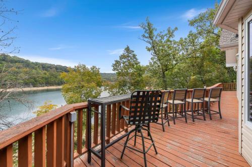 a deck with chairs and a view of a river at Beavershore-Direct Access to Beaver Lake-Sleeps 12 in Pine Top