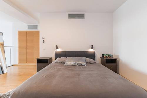 a bedroom with a large bed and two night stands at Loft moderno con terraza y piscina en Valencia in Burjasot