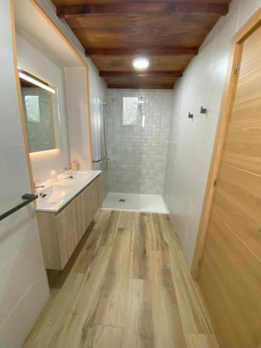 a bathroom with a shower and a sink and a mirror at Tranvía Beach House in Chipiona