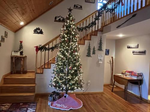 a christmas tree in a living room with a staircase at Smoky Mountain Getaway cabin in Cosby