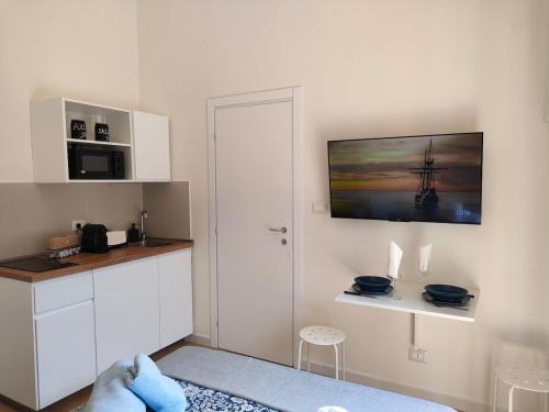 a kitchen with white cabinets and a picture of a ship on the wall at Noblerot in Turin