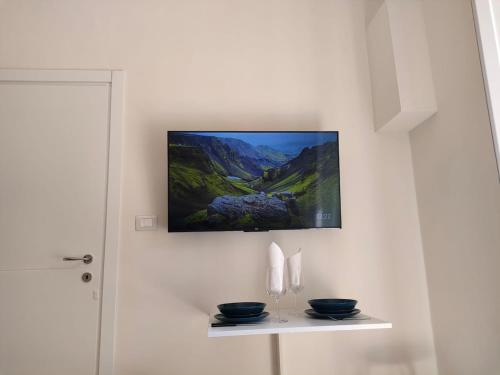 a painting on a wall with two bowls on a shelf at Noblerot in Turin