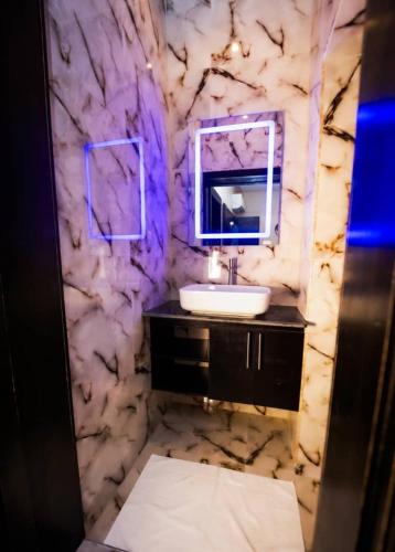 a marble bathroom with a sink and a mirror at Ralphnest Suite & Lounge Limited in Otta