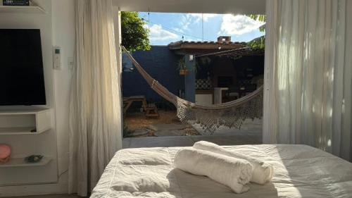 a bedroom with a hammock and a bed and a window at Charmosa hospedagem no Jardim Secreto SP in Sao Paulo