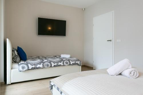 a bedroom with two beds and a tv on the wall at VIP Apartamenty Stara Polana 2 in Zakopane