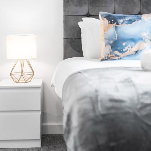 a bedroom with a bed and a nightstand with a lamp at Modern 2 Bed Apartment - Sleeps 3 - Netflix - Parking 55C in Sleightholme