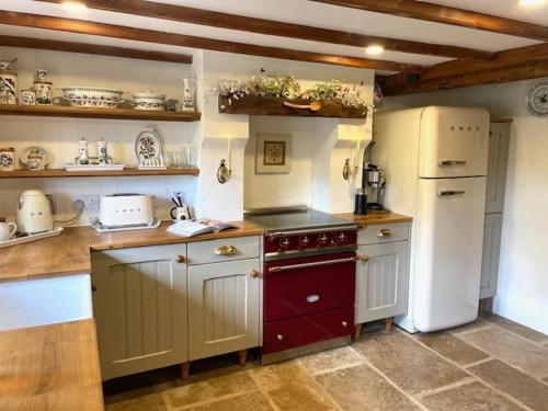 eine Küche mit Herd und Kühlschrank in der Unterkunft Fairytale Cottage in the Country in Hornton
