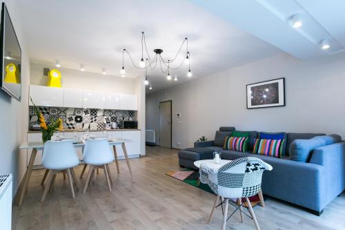 a living room with a blue couch and a table and chairs at VIP Apartamenty Stara Polana 2 in Zakopane