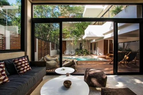 a living room with a couch and a table at Casa Kookay, 6BR Luxury Villa 3 Pools, Aldea Zama in Tulum
