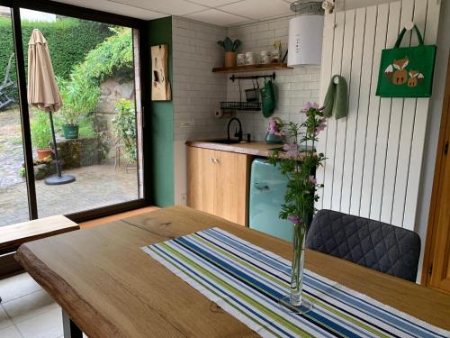 a kitchen with a wooden table with a vase on it at Éco-Gîte "La Chouette Verte" - Eco-Lodge "The Green Owl" in Wangenbourg