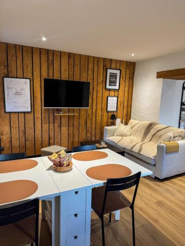 una sala de estar con un sofá y una mesa en A Cybiclette, en Saint-Étienne-lès-Remiremont