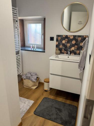 a bathroom with a sink and a mirror at A Cybiclette in Saint-Étienne-lès-Remiremont