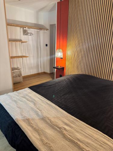 a bedroom with a large bed with a black blanket at A Cybiclette in Saint-Étienne-lès-Remiremont