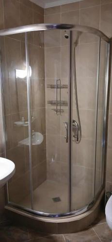 a shower with a glass door in a bathroom at Тайната квартира - The Secret apartment in Pamporovo
