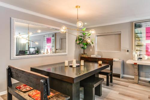 a dining room with a table and two benches at 1 Mi to Lake Worth Beach Park Poolside Paradise! in Lake Worth