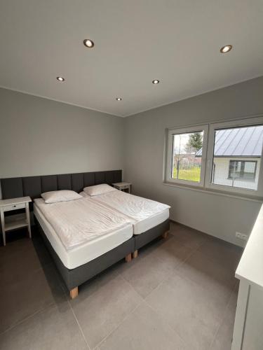 a bedroom with a large bed and a window at Domy całoroczne Cieszyno in Cieszyno
