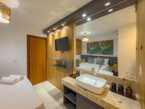een badkamer met een wastafel en een grote spiegel bij Mont Ararat Alto da Pitinga - Rede Tonziro in Porto Seguro
