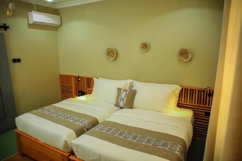 two beds sitting next to each other in a bedroom at The Dawn cottage in Moshi