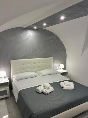 a bedroom with a large bed with towels on it at La 75 Stella Home Catania in Catania
